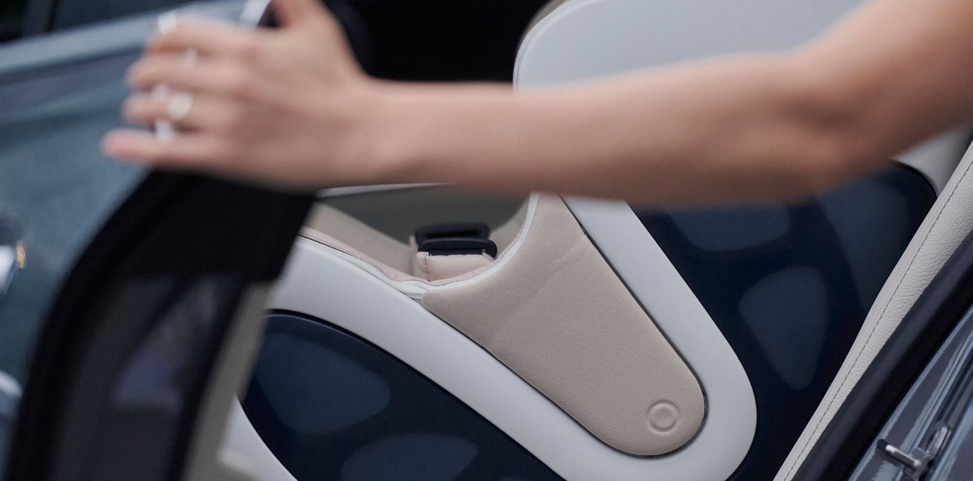 female hand on seat of a car with the babyark convertible car seat in the background